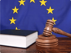 Image showing a gavel next to a law book. Both are in-front of an EU flag.